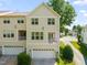 Exterior view of townhome with light siding, garages, and second-story balconies at 4703 Kings Garden Rd, Raleigh, NC 27612