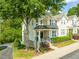 Three-story townhome with stone accents, a covered porch, and well-maintained landscaping at 4703 Kings Garden Rd, Raleigh, NC 27612