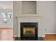 Close up of living room fireplace with white mantle and black granite surround at 4703 Kings Garden Rd, Raleigh, NC 27612