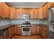 Kitchen with wood cabinets, stainless steel appliances, and tile backsplash at 4703 Kings Garden Rd, Raleigh, NC 27612