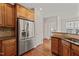 Kitchen featuring stainless steel refrigerator, wooden cabinets, and hardwood floors at 4703 Kings Garden Rd, Raleigh, NC 27612
