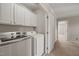 Convenient laundry room with white washer, dryer, and upper cabinets for storage at 4703 Kings Garden Rd, Raleigh, NC 27612