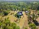 Aerial view of a home with a spacious yard, a storage shed, and mature trees, set back from the road at 494 Asset Pkwy, Sanford, NC 27332