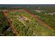 Wide aerial view highlighting home nestled within a large wooded parcel, clearly marked with a red property outline at 494 Asset Pkwy, Sanford, NC 27332