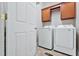 Bright laundry room features white washer and dryer and built-in wooden cabinets at 494 Asset Pkwy, Sanford, NC 27332