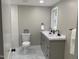 Updated bathroom features a double sink vanity, tile flooring, and a modern toilet at 502 Burton St, Fuquay Varina, NC 27526