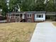 Charming brick home with a covered porch, black roof and gutters, carport, and a concrete driveway at 502 Burton St, Fuquay Varina, NC 27526