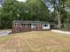 Charming brick home featuring a covered porch, carport, and a spacious front yard surrounded by mature trees at 502 Burton St, Fuquay Varina, NC 27526