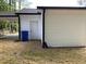 Side exterior view of the home with white siding, a blue trash can, and an attached carport at 502 Burton St, Fuquay Varina, NC 27526