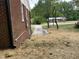 Side view showing brick home exterior with side yard; nearby home visible in the background at 502 Burton St, Fuquay Varina, NC 27526