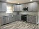Modern kitchen featuring granite countertops, new stainless steel appliances, gray cabinets and luxury vinyl flooring at 502 Burton St, Fuquay Varina, NC 27526