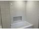 Shower boasts subway tiling, a built-in shelf, and a bathtub at 502 Burton St, Fuquay Varina, NC 27526