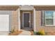 Close-up view of the front door with brick accents and manicured landscaping at 505 Lochalsh Dr, Gibsonville, NC 27249