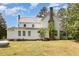 Exterior shows large backyard, white siding, stone chimney, and metal roof, blending country charm at 5062 Dorsey Rd, Oxford, NC 27565