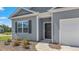 Close-up of a home's front entrance with a dark door, landscaping, and a two-car garage at 514 Lochalsh Dr, Gibsonville, NC 27249