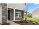 Welcoming covered front porch with stone detail and manicured garden at 522 Lochalsh Dr, Gibsonville, NC 27249