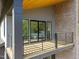 Upper-level balcony with wood flooring, black railings, brick columns, and gray siding at 528 1/2 Bragg St, Raleigh, NC 27610