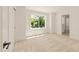Bright bedroom with a large window offering a view of lush greenery and connecting ensuite bathroom at 528 1/2 Bragg St, Raleigh, NC 27610