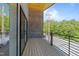 Stylish balcony featuring wood floors, brick wall, and a sleek black railing at 528 Bragg St, Raleigh, NC 27610
