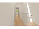 Bright hallway with hardwood floors and white walls leading to a room with natural light at 528 Bragg St, Raleigh, NC 27610