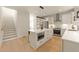 Open concept kitchen features a white island, stainless appliances, and easy access to the dining area at 528 Bragg St, Raleigh, NC 27610