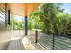 Relaxing covered porch with wood flooring and contemporary black railings surrounded by lush landscaping at 528 Bragg St, Raleigh, NC 27610