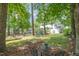 Spacious backyard offers a peaceful retreat with mature trees, hammock, and outdoor seating area at 5312 Hallmark Rd, Durham, NC 27712