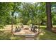 Backyard fire pit with Adirondack chairs, mature trees, and space for relaxing and entertaining at 5312 Hallmark Rd, Durham, NC 27712