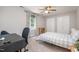 Bedroom featuring a ceiling fan, a window with curtains, and closet doors at 5312 Hallmark Rd, Durham, NC 27712