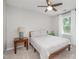 Bright bedroom featuring a window, ceiling fan, and a side table with a lamp at 5312 Hallmark Rd, Durham, NC 27712