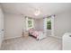 Bright bedroom with white carpet and a bed between two windows at 5312 Hallmark Rd, Durham, NC 27712