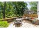 Outdoor deck furnished with cushioned seating and a dining area under the shade of trees at 5312 Hallmark Rd, Durham, NC 27712