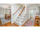 Bright foyer featuring a staircase with white railings, hardwood floors, and views into dining room at 5312 Hallmark Rd, Durham, NC 27712