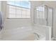 Clean white bathtub with window view and glass enclosed shower at 5912 Hourglass Ct, Raleigh, NC 27612