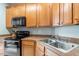Efficient kitchen with wooden cabinetry, stainless steel sink, and modern appliances at 5912 Hourglass Ct, Raleigh, NC 27612