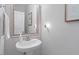 Stylish powder room featuring a pedestal sink, decorative mirror, and elegant decor at 5912 Hourglass Ct, Raleigh, NC 27612
