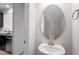 Stylish powder room with pedestal sink and oval mirror at 709 Wickham Ridge Rd, Apex, NC 27539