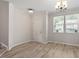 Versatile room with hardwood flooring, crown molding, and large windows, ideal for customization at 709 Wickham Ridge Rd, Apex, NC 27539