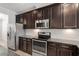 Modern kitchen with granite countertops, stainless steel appliances, and dark wood cabinets at 709 Wickham Ridge Rd, Apex, NC 27539