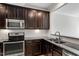 Modern kitchen with granite countertops, stainless steel appliances, and dark wood cabinets at 709 Wickham Ridge Rd, Apex, NC 27539