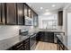 Modern kitchen with granite countertops, stainless steel appliances, and dark wood cabinets at 709 Wickham Ridge Rd, Apex, NC 27539