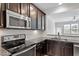 Modern kitchen with granite countertops, stainless steel appliances, and dark wood cabinets at 709 Wickham Ridge Rd, Apex, NC 27539