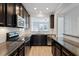 Modern kitchen with granite countertops, stainless steel appliances, and dark wood cabinets at 709 Wickham Ridge Rd, Apex, NC 27539