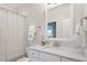 A bright bathroom featuring a marble countertop, vanity, and white framed mirror above the sink at 715 Kimbrough St, Raleigh, NC 27608