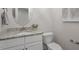 Clean half bathroom with granite countertops and a toilet with white cabinets offering storage at 715 Kimbrough St, Raleigh, NC 27608