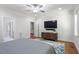This bedroom features a mounted TV, dresser, and view into the beautiful ensuite bathroom at 715 Kimbrough St, Raleigh, NC 27608