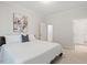 Neutral primary bedroom boasts a large bed with crisp white bedding, ensuite access, and an abstract art piece at 715 Kimbrough St, Raleigh, NC 27608