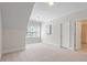 This empty, carpeted bedroom features a large window and ample space to customize at 715 Kimbrough St, Raleigh, NC 27608