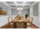 Elegant dining room featuring coffered ceilings, wainscoting, hardwood floors, and a chandelier at 715 Kimbrough St, Raleigh, NC 27608
