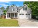 Beautiful two-story home with white brick, a covered porch, and an attached two-car garage at 715 Kimbrough St, Raleigh, NC 27608